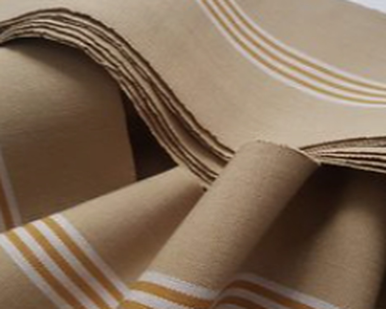 Folded lengths of hand-woven Aṣọ-òkè in natural sanyan beige with ivory stripes